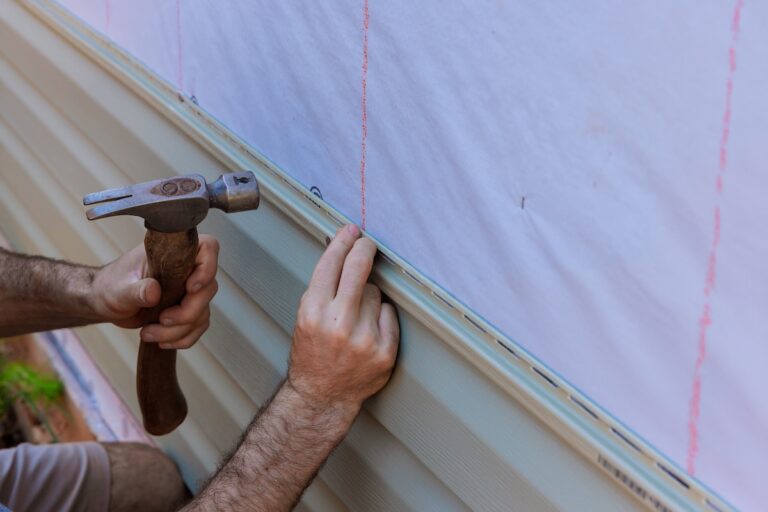 Handyman installs vinyl PVC siding on new home facade