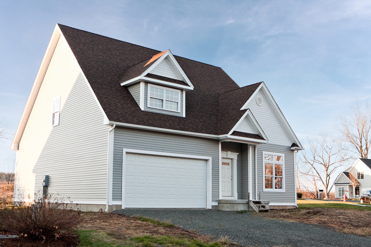 Modern custom built house newly constructed with a two car garage in a residential neighborhood.