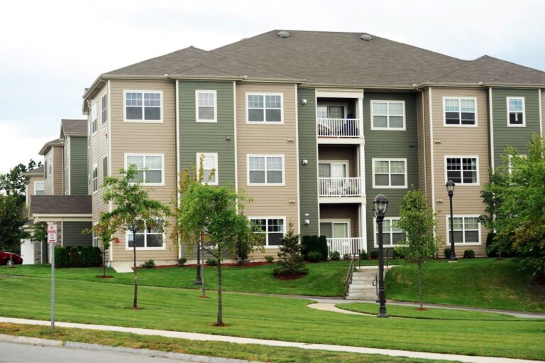 green apartment buildings with asphalt shingle roofs