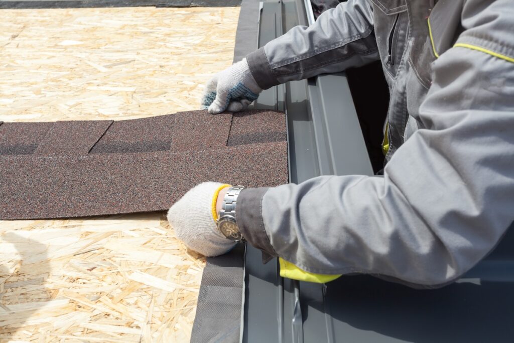 roofer installing asphalt shingles