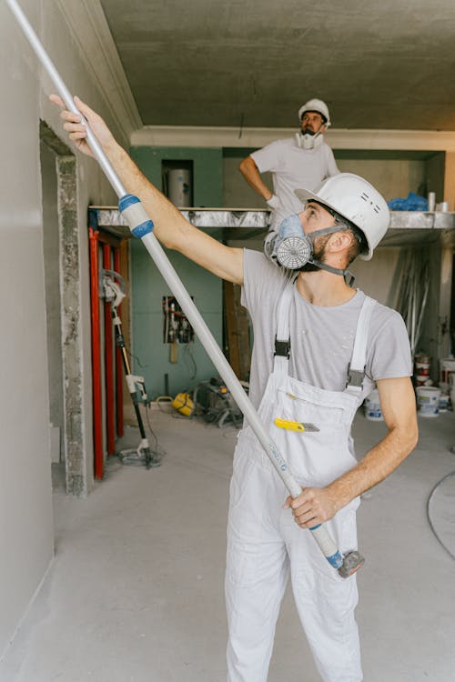 Roofing crew renovating and installing asphalt shingles on a suburban home