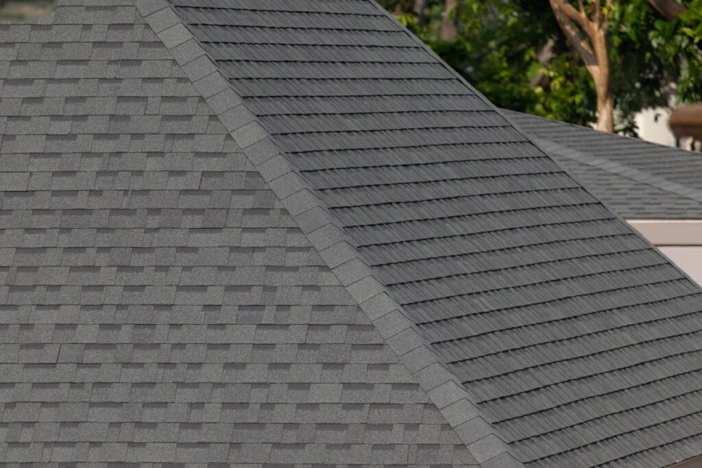 Dark gray shingles line a sloped roof with neat rows