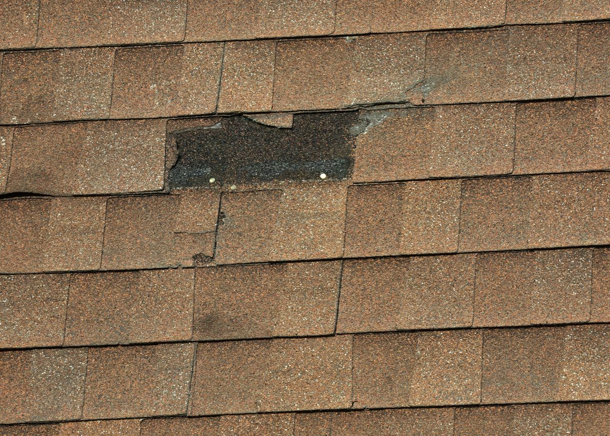 missing shingle on a brown shingle roof