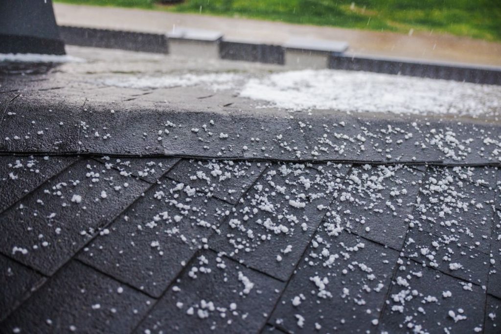 Small hailstones falling and covering a dark shingled roof during a rainstorm, Arden Hills