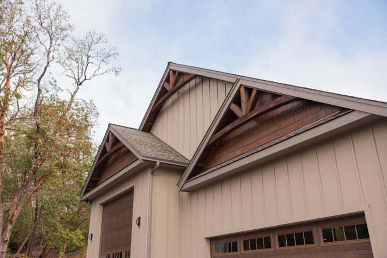 Large garage bays with arches on the roof and board and batten siding
