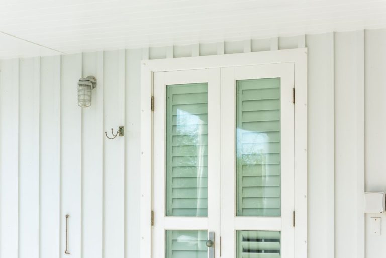 Pastel green colorful hurricane window shutters architecture open exterior of house