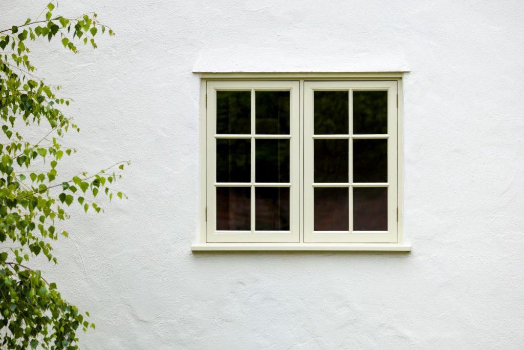 white house with a beige window next to a tree